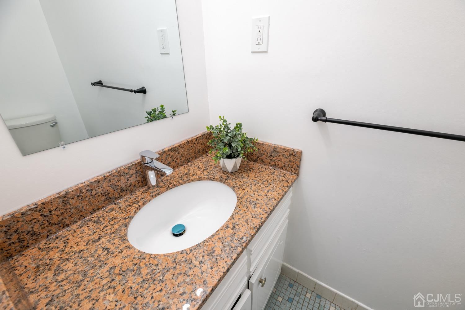 7101 Hana Road Edison, NJ 08817 - Photo 31 of 77 a bathroom with a granite countertop sink and a mirror