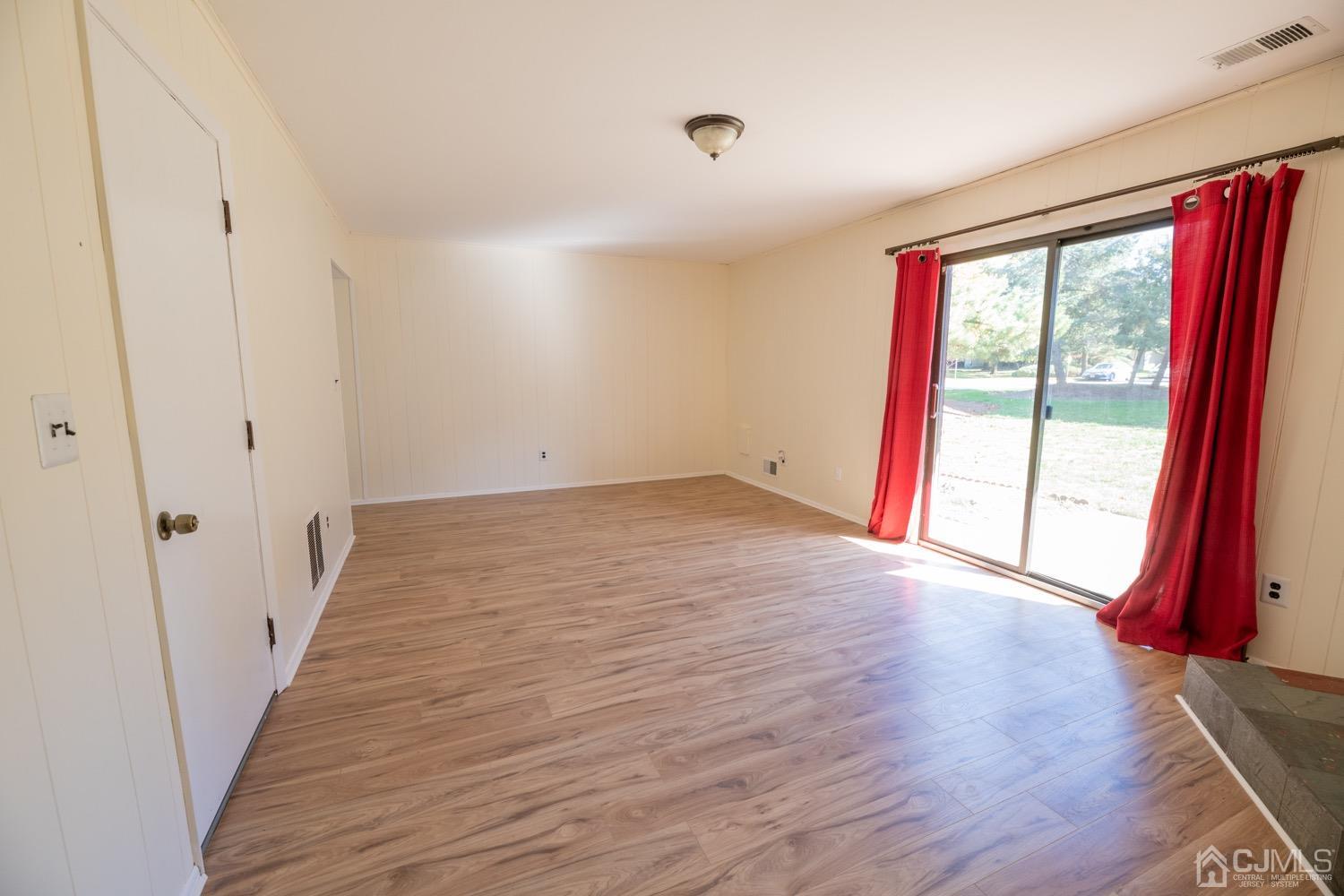 7101 Hana Road Edison, NJ 08817 - Photo 40 of 77 a view of an empty room with wooden floor and a window