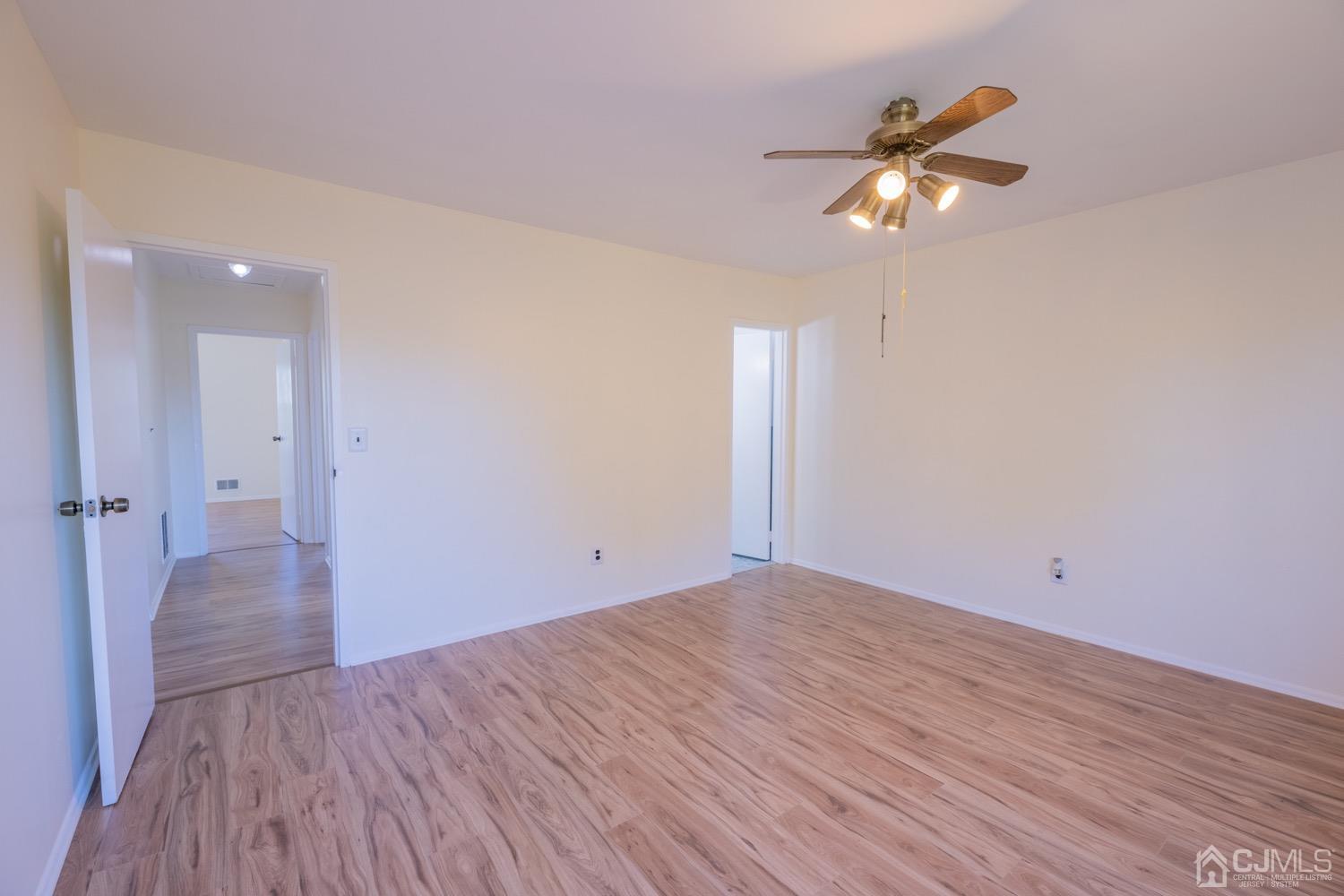 7101 Hana Road Edison, NJ 08817 - Photo 49 of 77 an empty room with wooden floor fan and windows