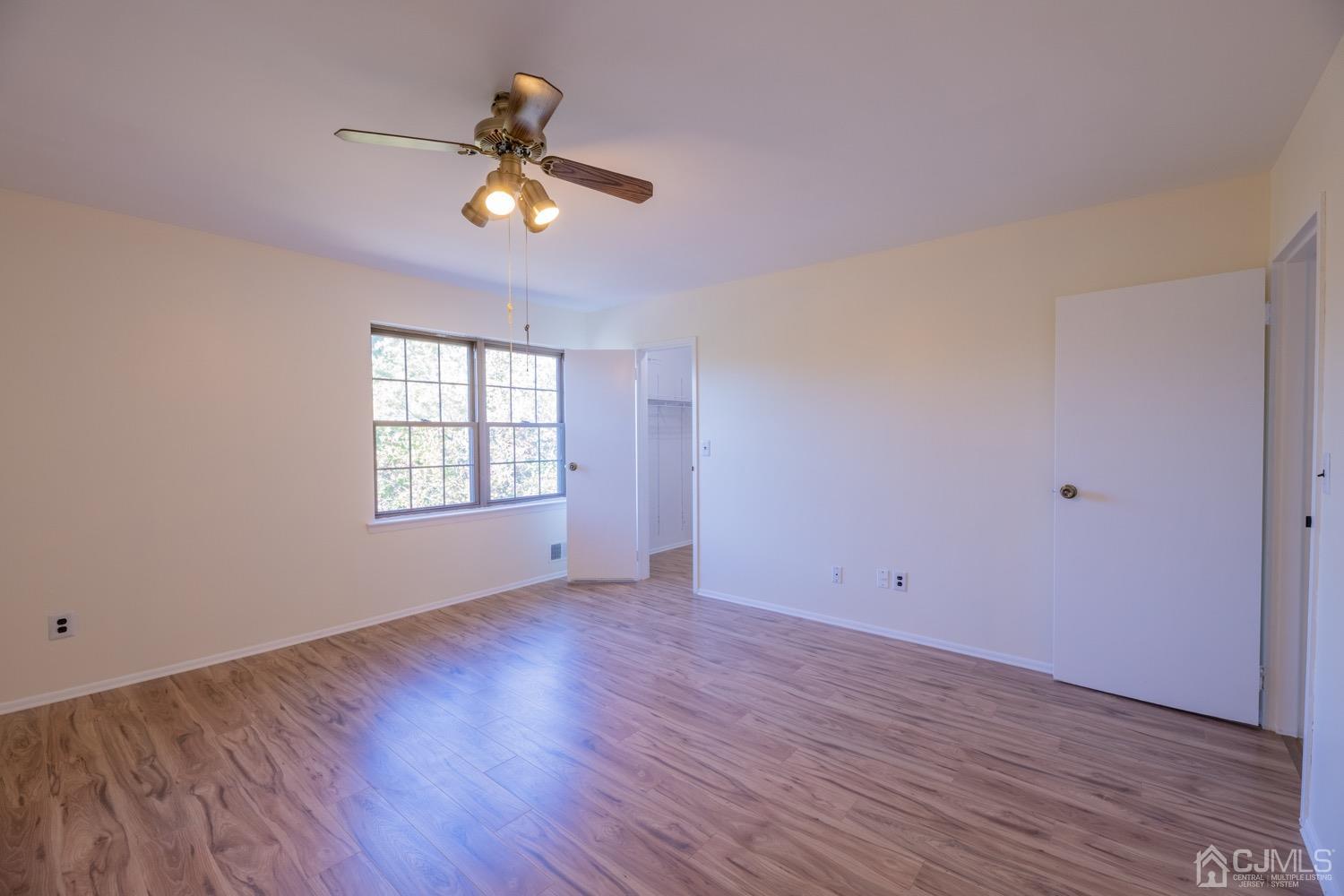 7101 Hana Road Edison, NJ 08817 - Photo 50 of 77 a view of empty room with wooden floor and fan
