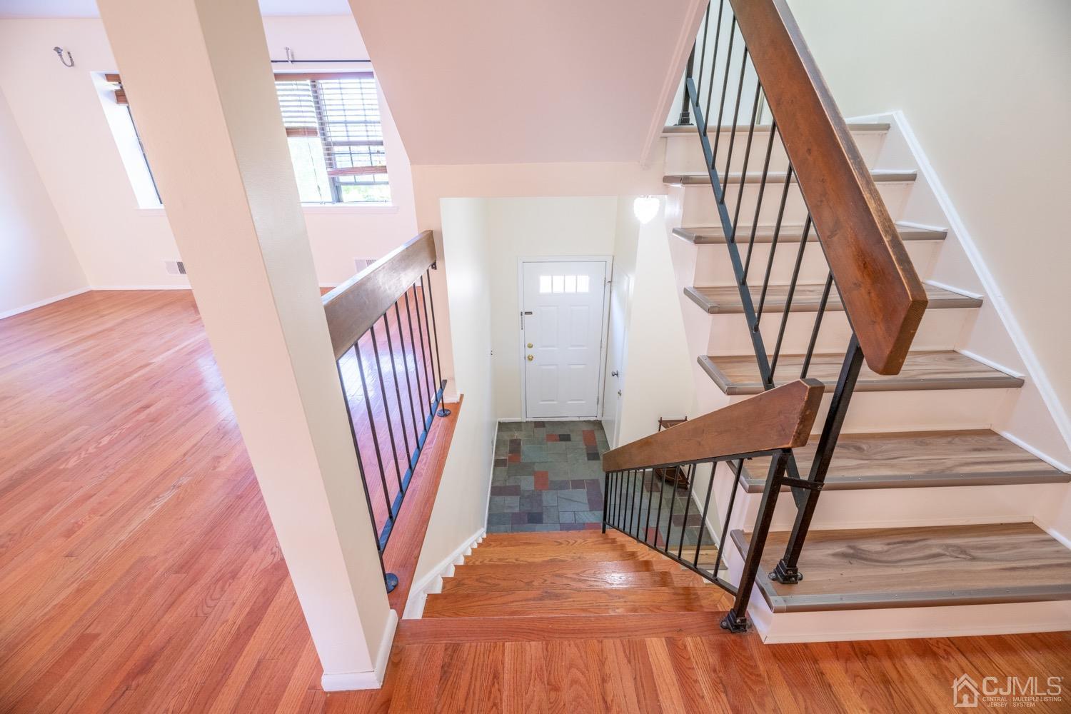 7101 Hana Road Edison, NJ 08817 - Photo 5 of 77 a view of staircase with white walls and a wooden floor