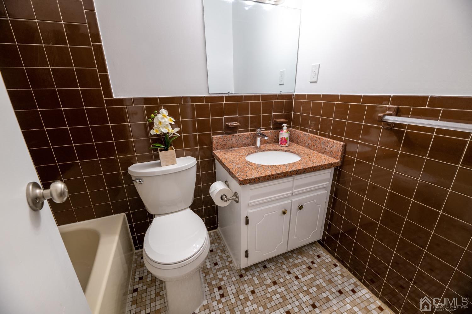 7101 Hana Road Edison, NJ 08817 - Photo 59 of 77 a bathroom with a toilet a sink and a mirror