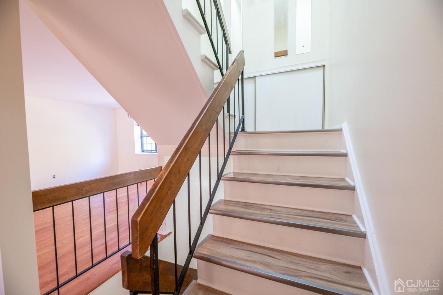 7101 Hana Road Edison, NJ 08817 - Photo 7 of 77 a view of staircase with wooden floor and white walls
