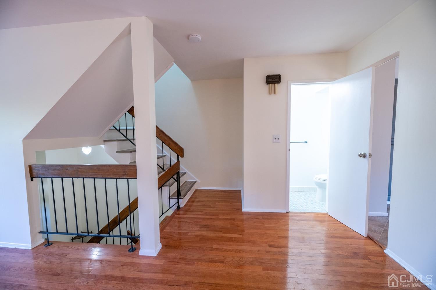 7101 Hana Road Edison, NJ 08817 - Photo 8 of 77 a view of a hallway with wooden floor and stairs