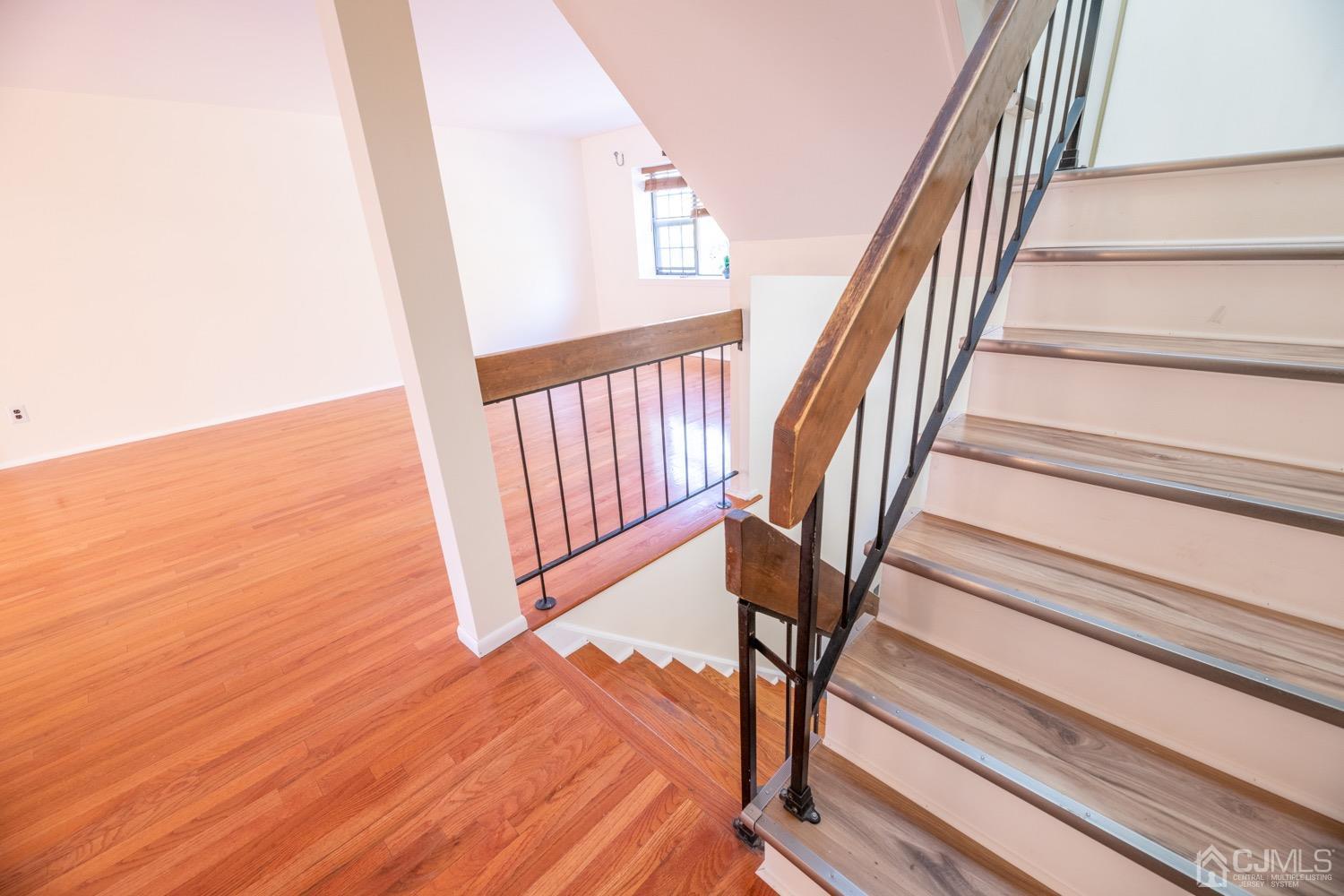7101 Hana Road Edison, NJ 08817 - Photo 9 of 77 a view of staircase with white walls and railing