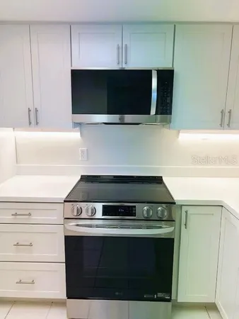a close view of a refrigerator in kitchen and white cabinets