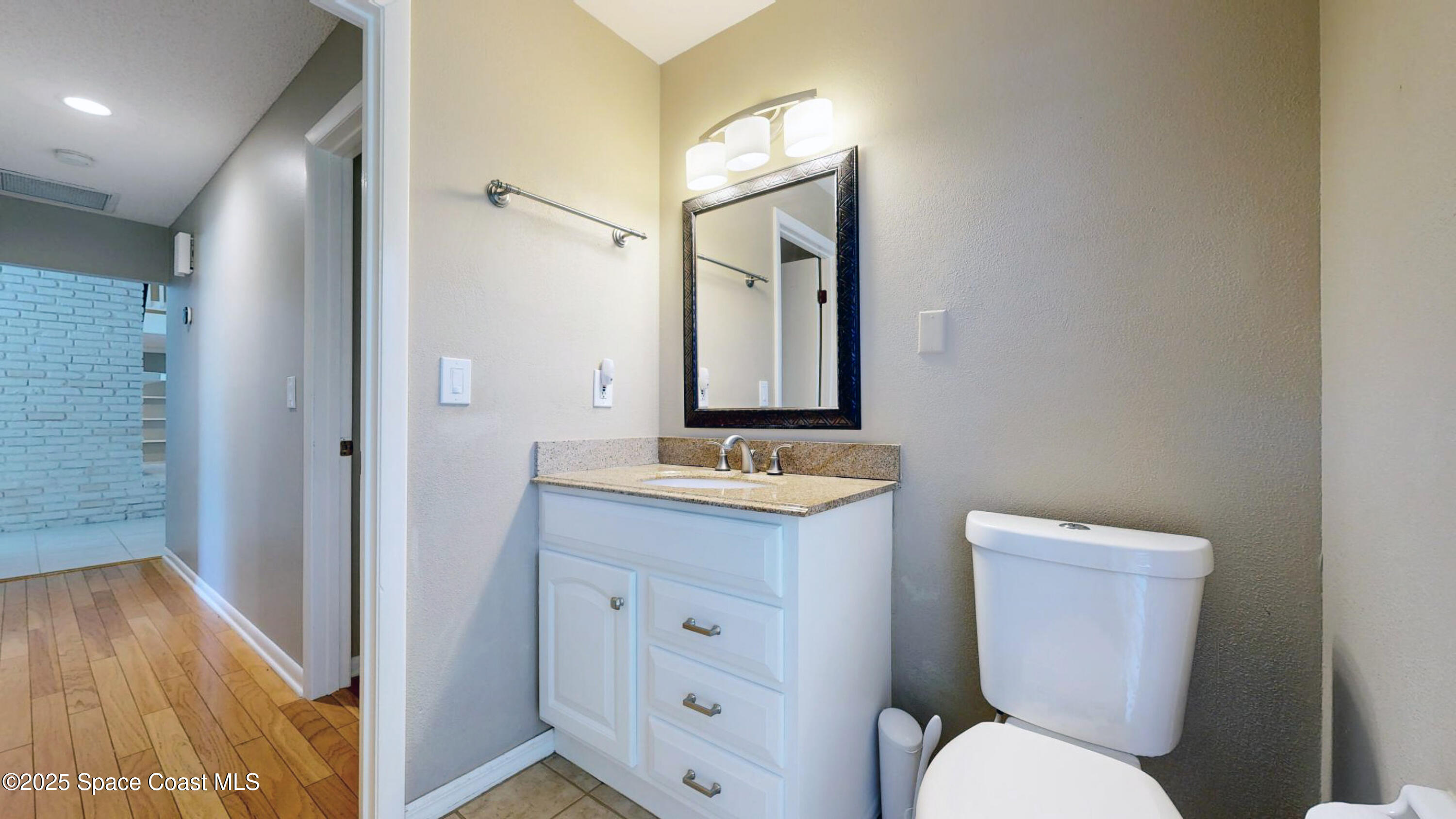 800 Inverness Avenue Melbourne, FL 32940 - Photo 17 of 22 a bathroom with a toilet a sink and mirror