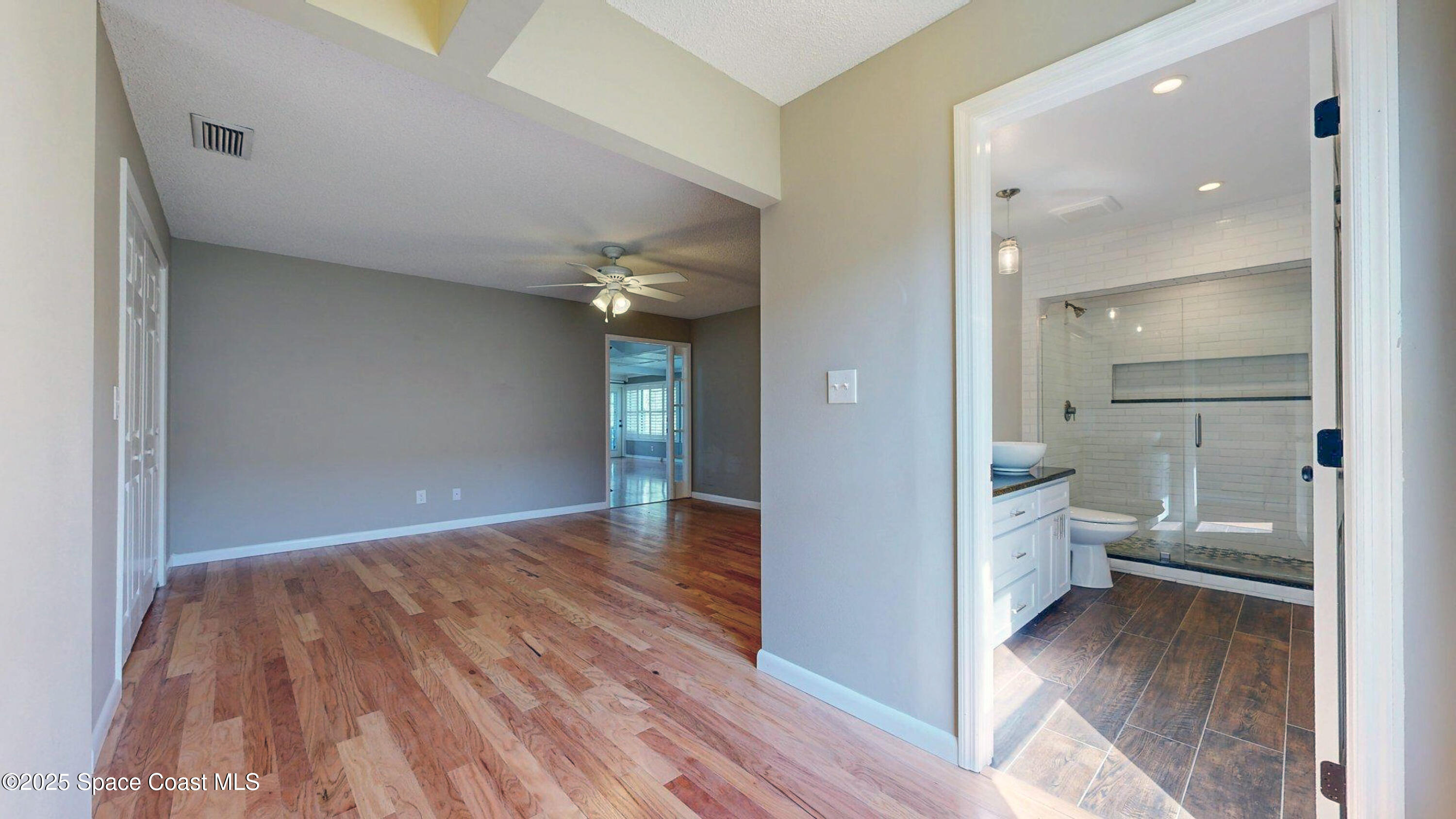 800 Inverness Avenue Melbourne, FL 32940 - Photo 19 of 22 a view of a hallway with wooden floor and a bathroom