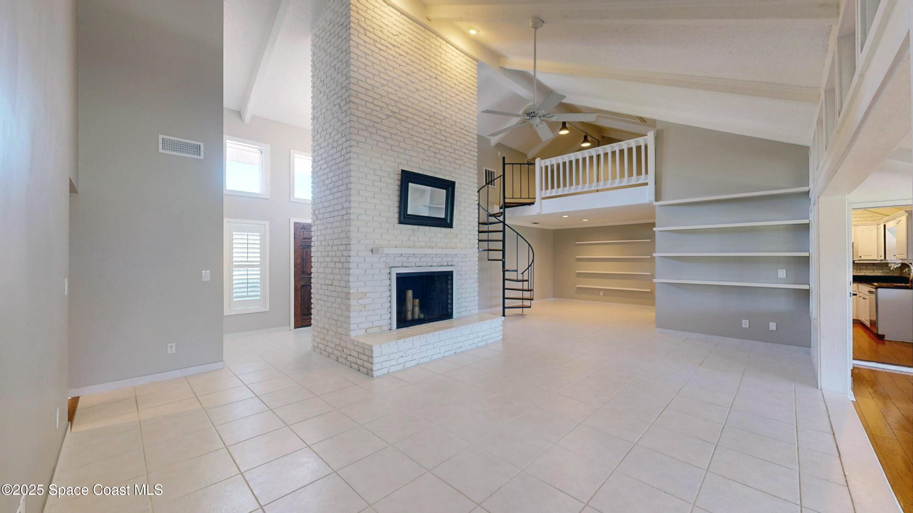 800 Inverness Avenue Melbourne, FL 32940 - Photo 4 of 22 a view of an empty room with a fireplace and a window