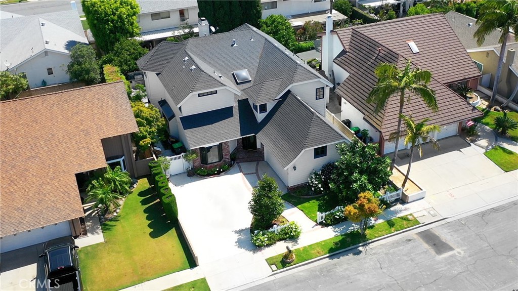 an aerial view of a house with a yard and a large tree