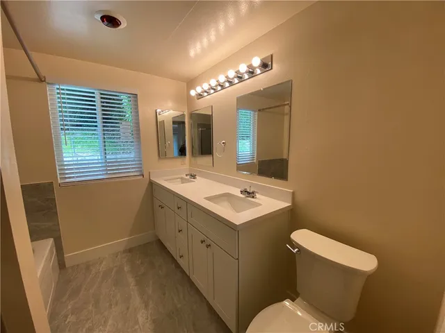 a bathroom with a sink a toilet and mirror