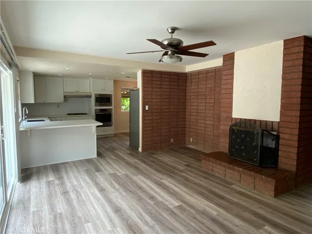a view of kitchen with cabinets appliances and wooden floor