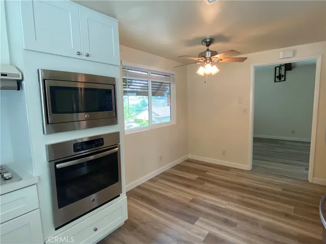 a kitchen with stainless steel appliances a stove a microwave and a hard wood floor