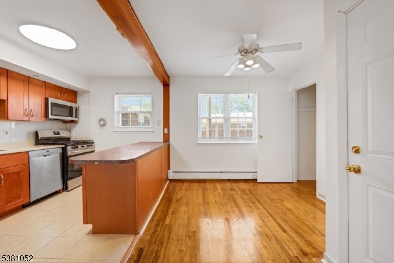 1285 Valley Road Wayne, NJ 07470 - Photo 12 of 33 a large kitchen with stainless steel appliances granite countertop a stove a sink dishwasher and a refrigerator with wooden floor