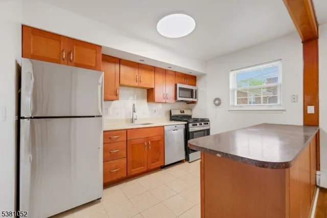 a kitchen with stainless steel appliances granite countertop a refrigerator sink stove and cabinets