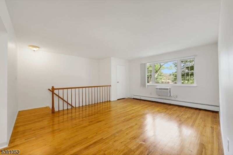 1285 Valley Road Wayne, NJ 07470 - Photo 3 of 33 a view of an empty room with wooden floor and a window