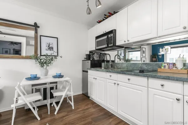 a kitchen with stainless steel appliances granite countertop white cabinets a sink and dishwasher with wooden floor
