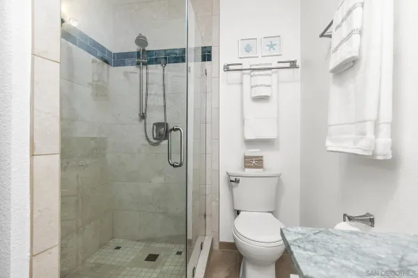 a bathroom with a granite countertop toilet a sink and shower