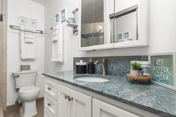 a bathroom with a granite countertop sink and a mirror
