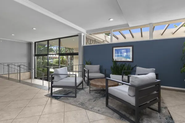 a living room with a table chairs and a potted plant