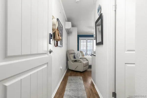 a hallway with white cabinets and wooden floor