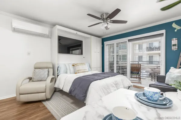 a bedroom with a balcony a bed and a flat screen tv