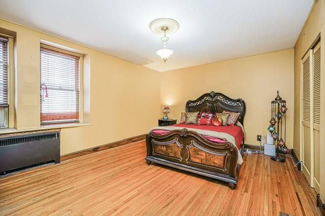 8701 Shore Road, Unit 421 Brooklyn, NY 11209 - Photo 14 of 20 a bedroom with a bed and wooden floor
