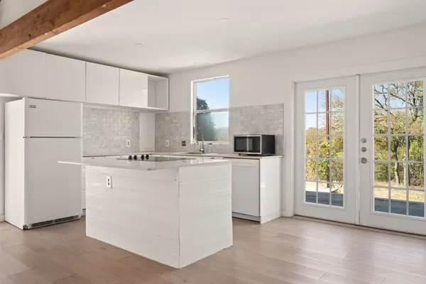 a kitchen with kitchen island white cabinets and refrigerator
