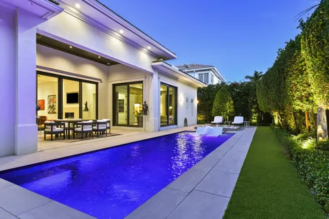 a view of swimming pool with lawn chairs and couches