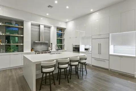 a kitchen with a table chairs refrigerator and cabinets