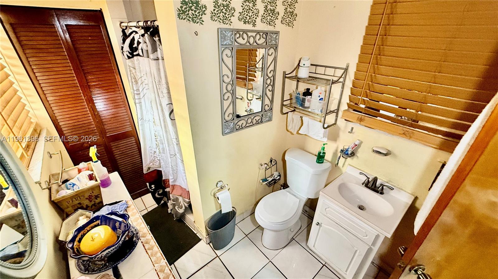 46 Northwest 24th Court Miami, FL 33125 - Photo 11 of 19 a bathroom with a toilet sink and mirror