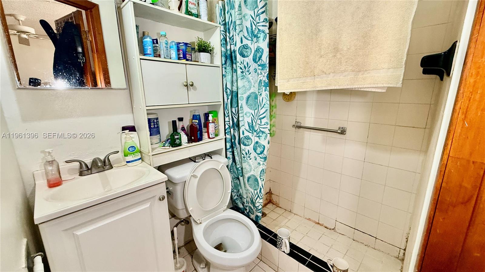 46 Northwest 24th Court Miami, FL 33125 - Photo 14 of 19 a bathroom with a sink a toilet and a shower curtain