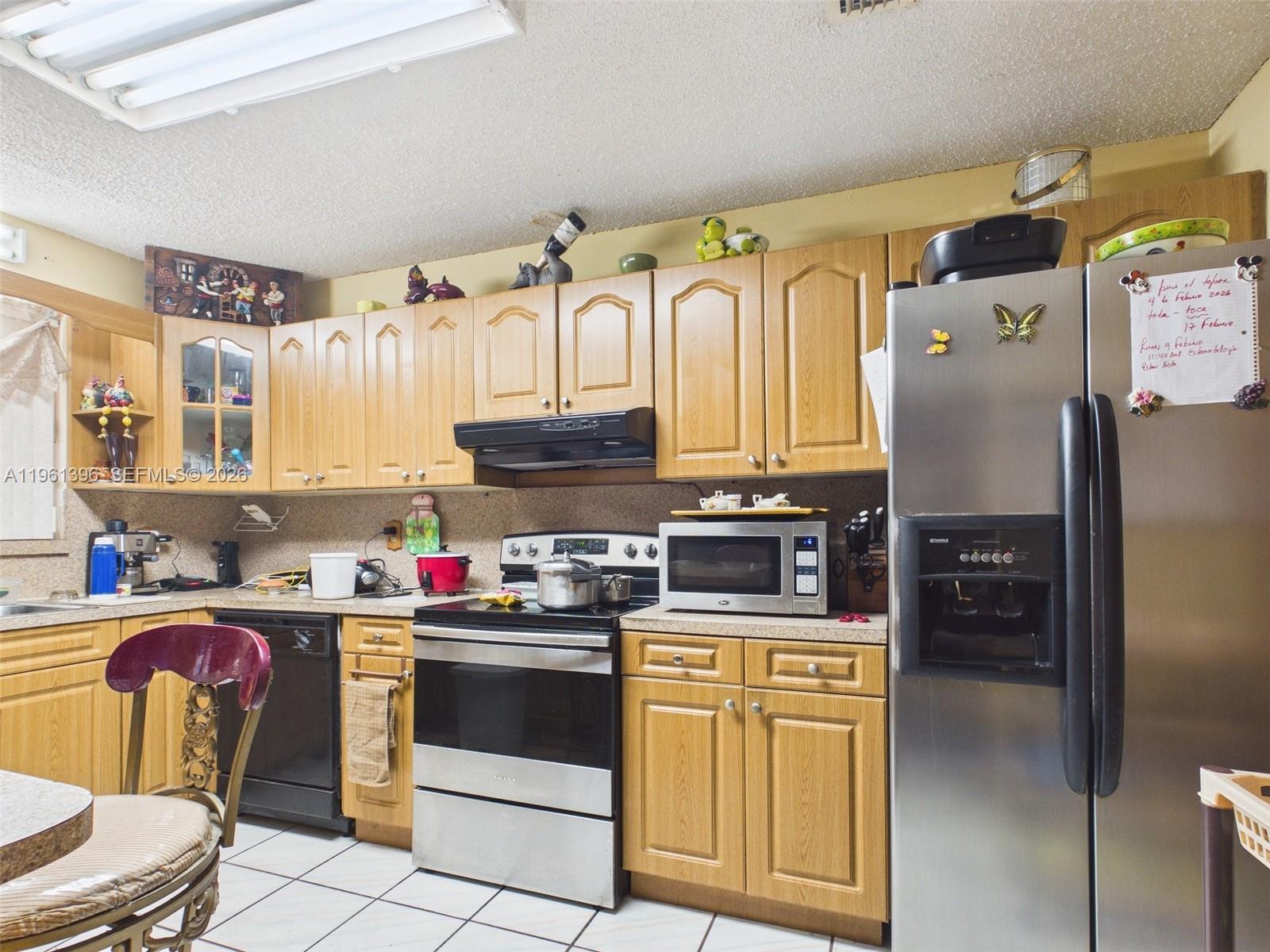 46 Northwest 24th Court Miami, FL 33125 - Photo 10 of 19 a kitchen with stainless steel appliances granite countertop a refrigerator a stove top oven and a sink