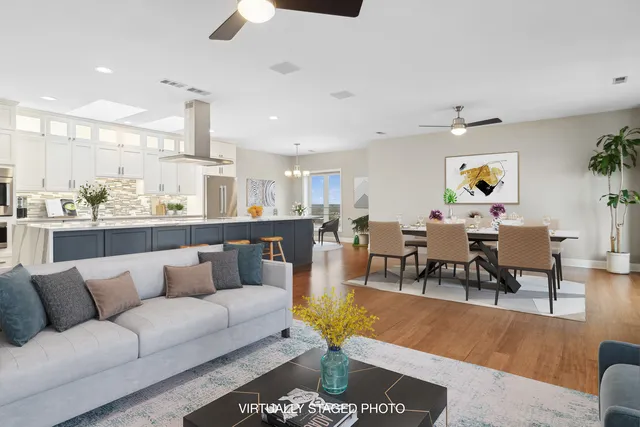a living room with furniture kitchen view and a chandelier