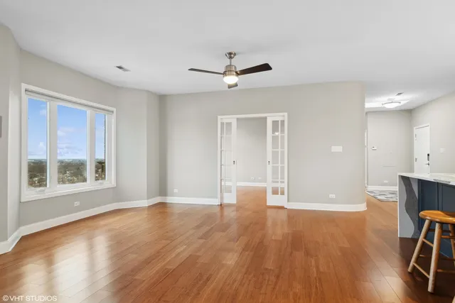 a view of an empty room with a window and wooden floor