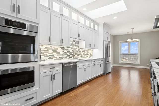 a kitchen with stainless steel appliances white cabinets and a fireplace