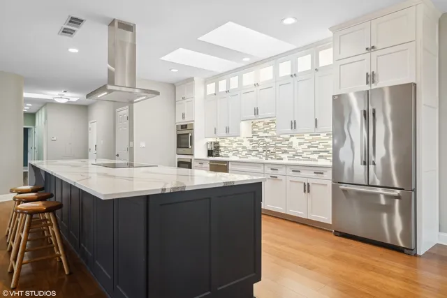 a kitchen with kitchen island granite countertop a sink appliances cabinets and a counter top space