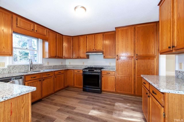 a kitchen with stainless steel appliances granite countertop wooden cabinets a sink and a stove