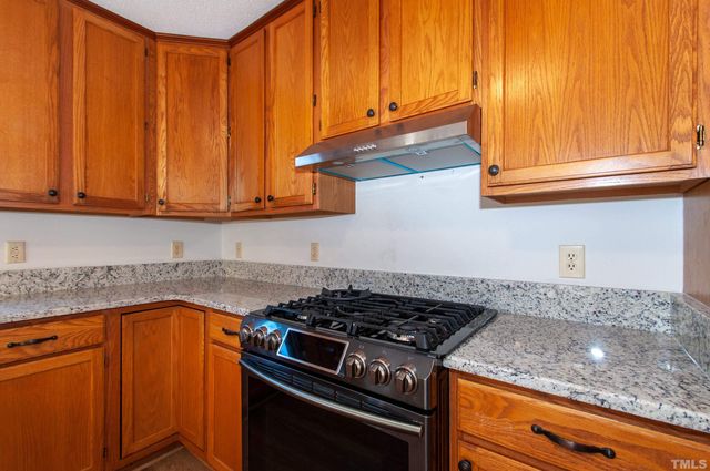 a kitchen with granite countertop wood cabinets and stainless steel appliances