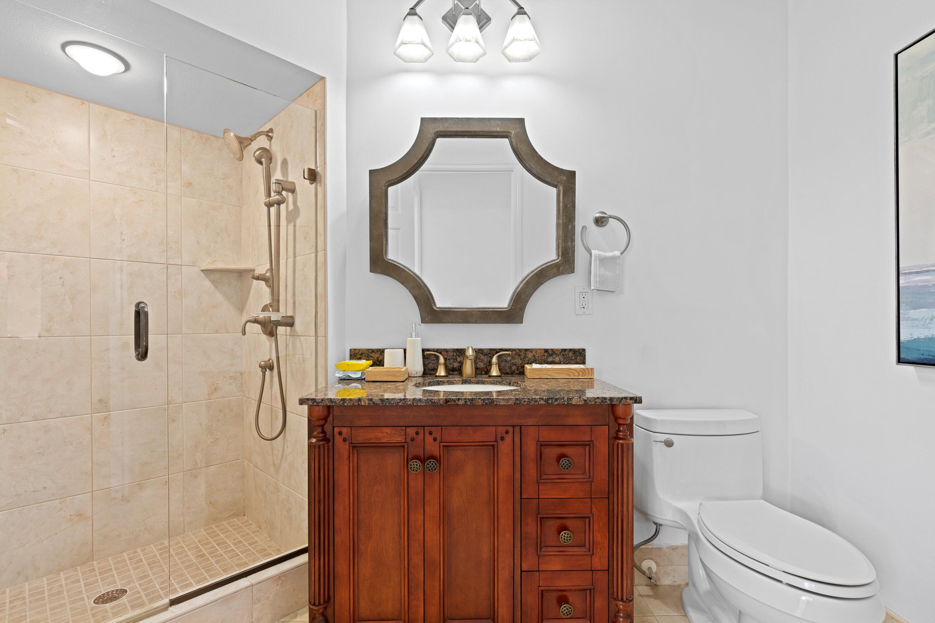 202 Sea Oats Drive Juno Beach, FL 33408 - Photo 17 of 17 a bathroom with a granite countertop toilet a sink and a mirror