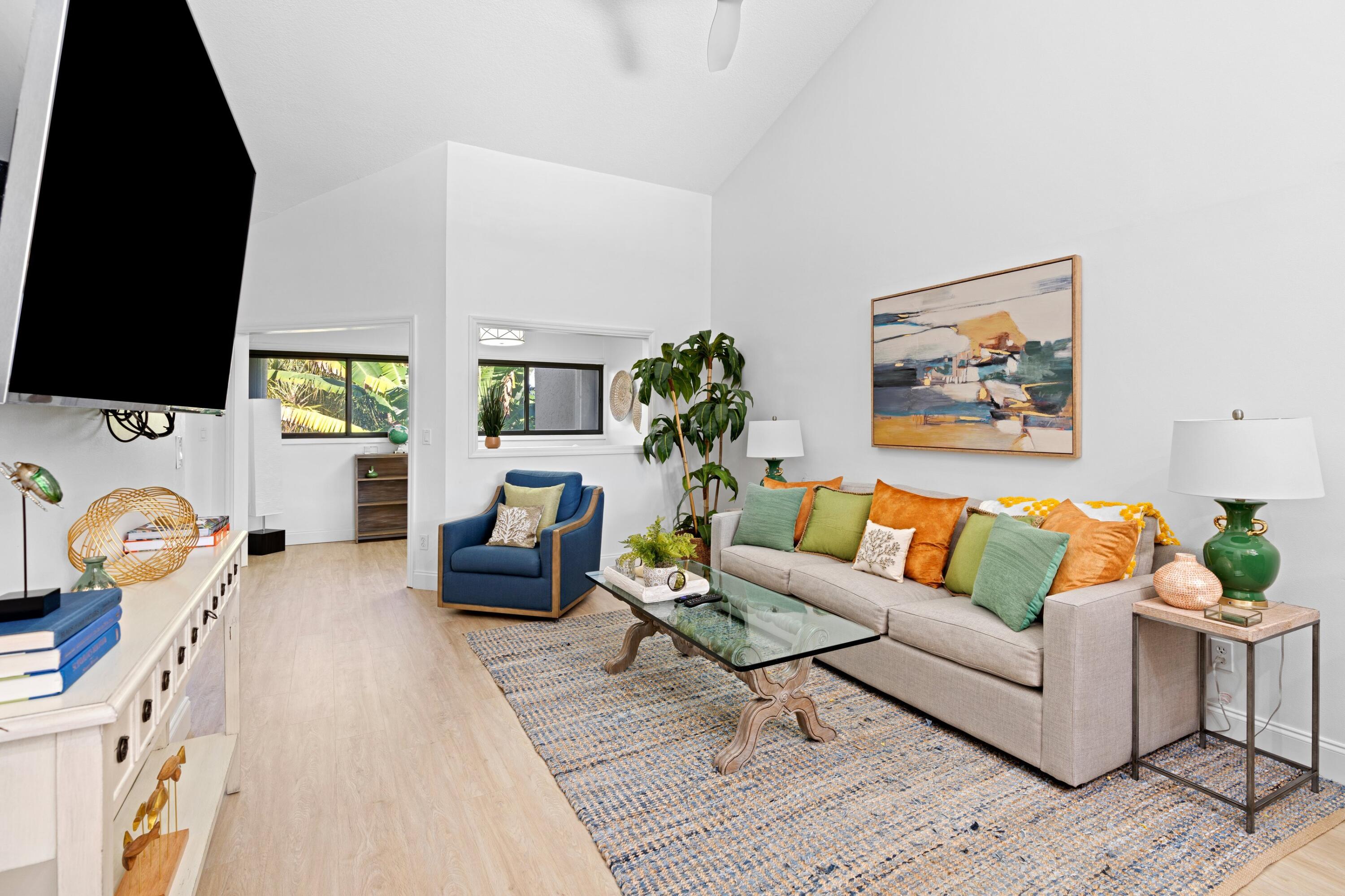 202 Sea Oats Drive Juno Beach, FL 33408 - Photo 3 of 17 a living room with furniture a flat screen tv and a fireplace