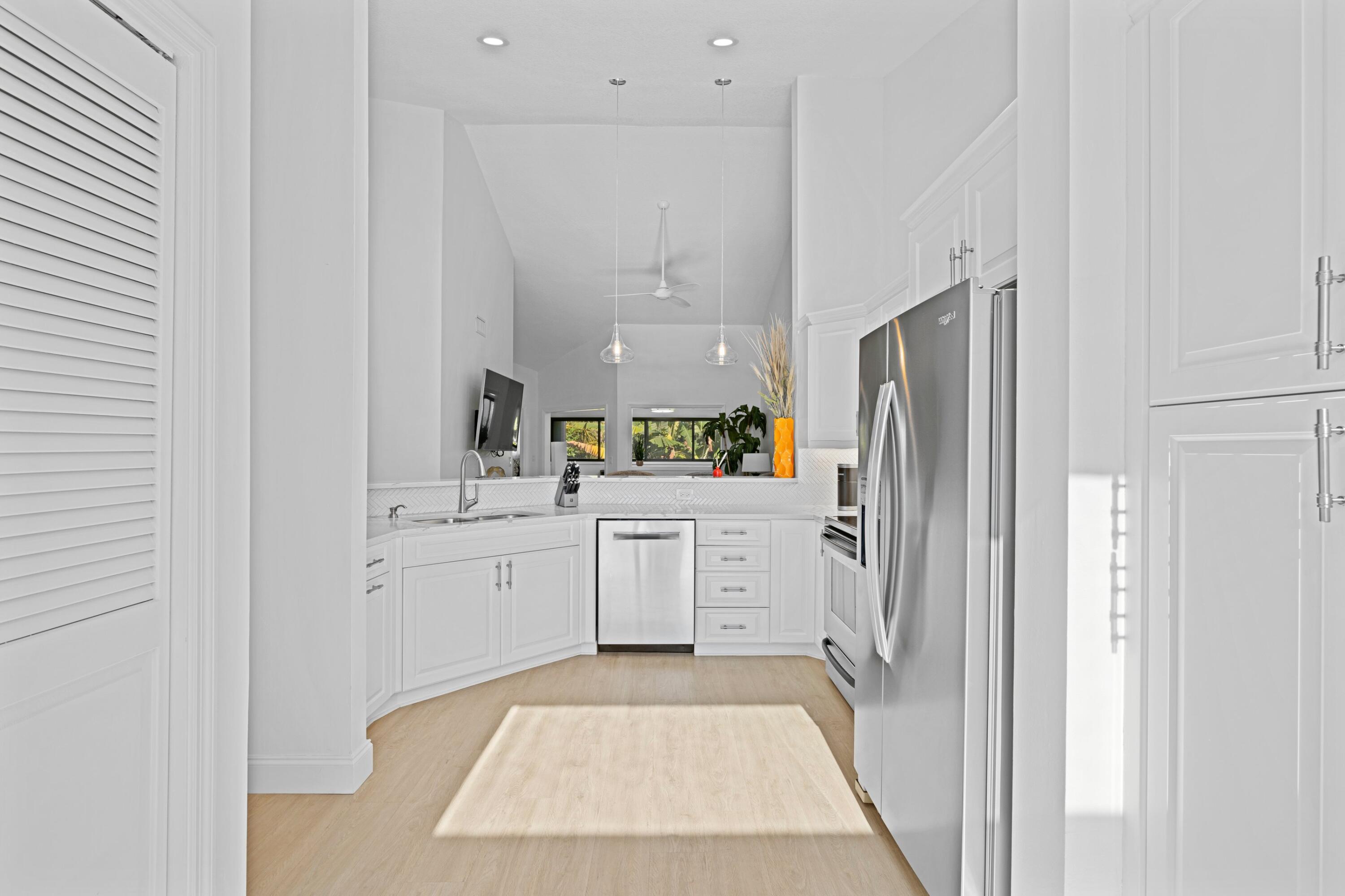 202 Sea Oats Drive Juno Beach, FL 33408 - Photo 6 of 17 a kitchen with white cabinets and refrigerator