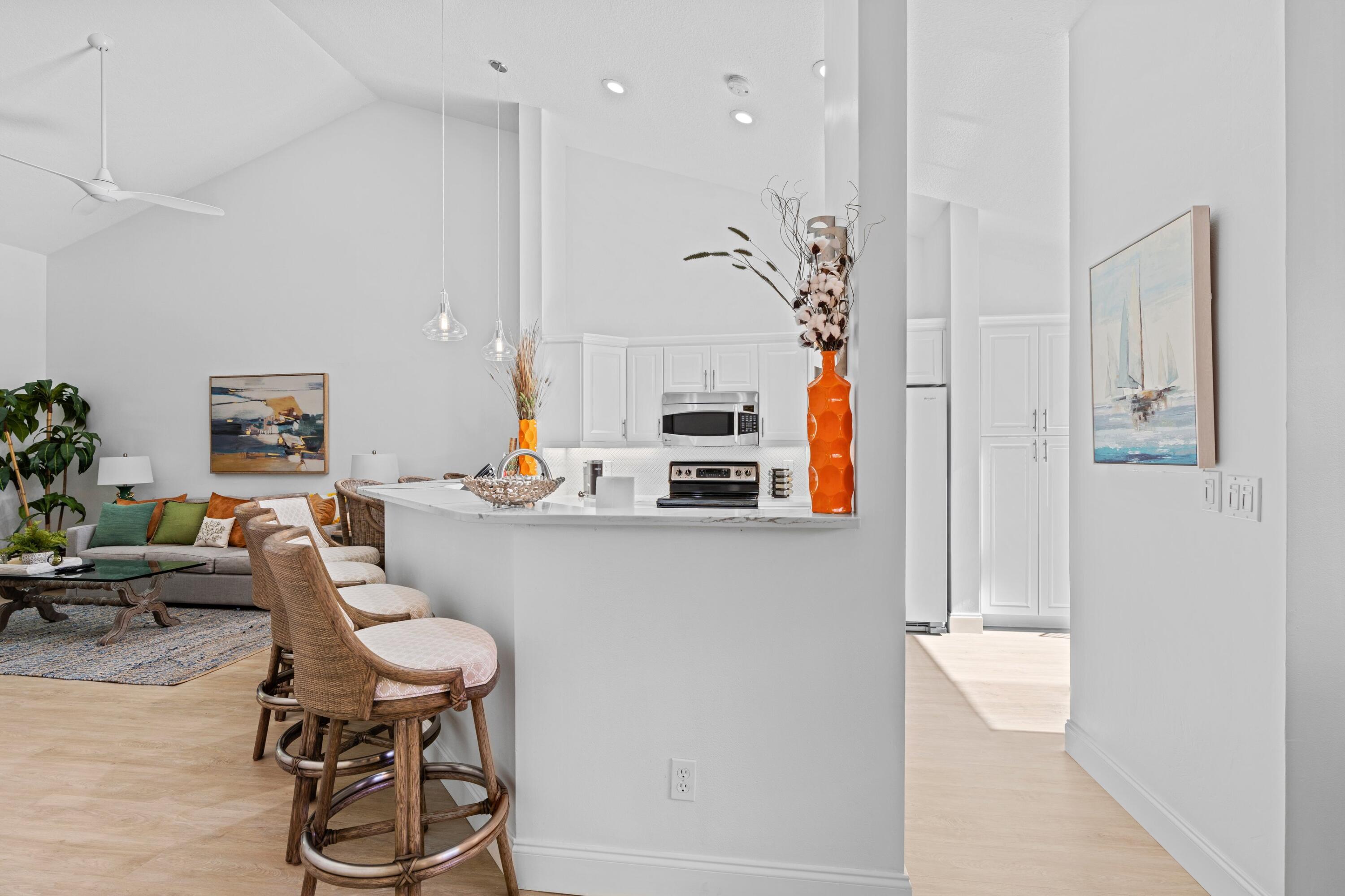 202 Sea Oats Drive Juno Beach, FL 33408 - Photo 9 of 17 a living room with furniture a table and kitchen view