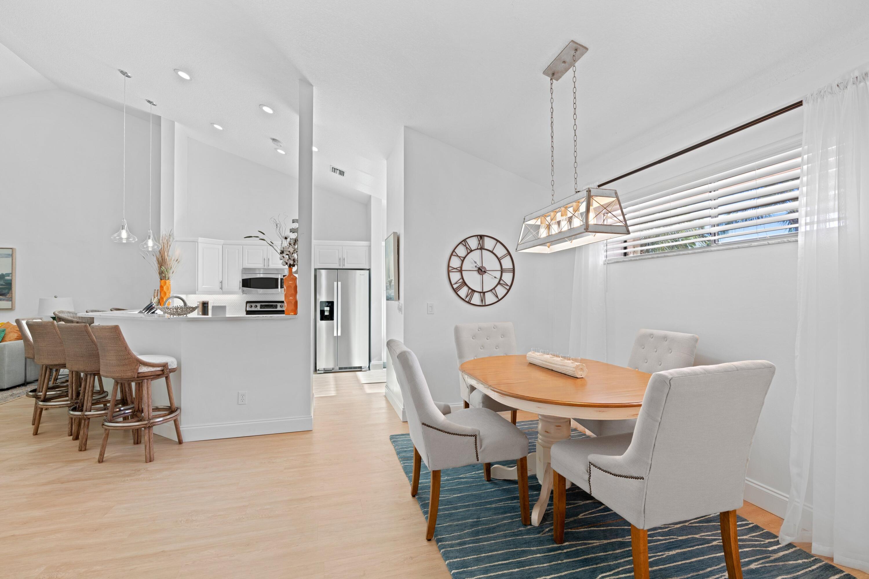 202 Sea Oats Drive Juno Beach, FL 33408 - Photo 10 of 17 a view of dining room and livingroom with furniture wooden floor and a chandelier