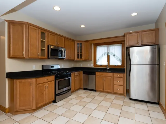 a kitchen with stainless steel appliances granite countertop a refrigerator sink and microwave