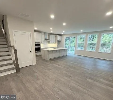 a large kitchen with a large window and wooden floor