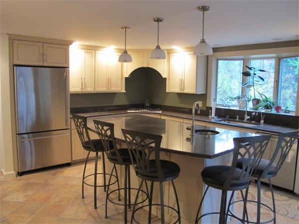 10 Anthony Road Wayland, MA 01778 - Photo 6 of 17 a kitchen with stainless steel appliances granite countertop a table chairs and a refrigerator