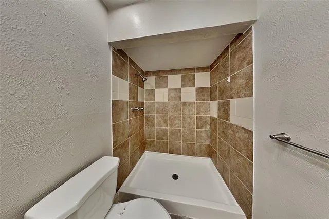 a bathroom with a toilet and shower