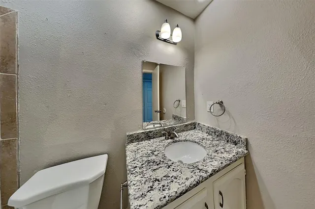 a bathroom with a granite countertop sink and a mirror