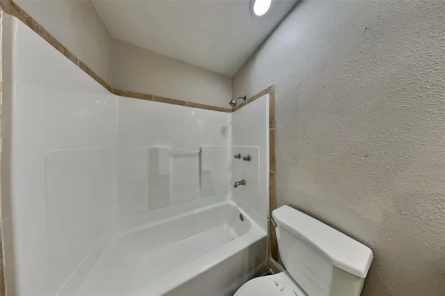 a bathroom with a toilet and a bath tub